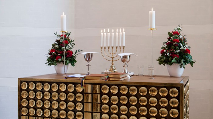 En smykket juledekorationsopstilling med lysestage og lille juletræer