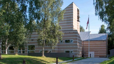 Et moderne bygning med træpanel og flagstang foran