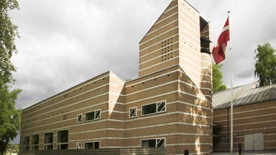 Bygningen er lavet af træ og har en moderne, geometrisk form.
