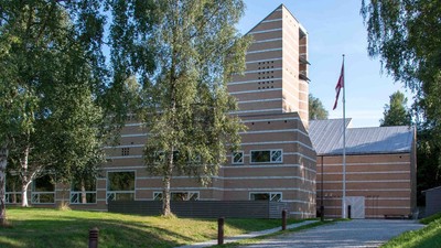 Et moderne bygning med træpanel og flagstang foran