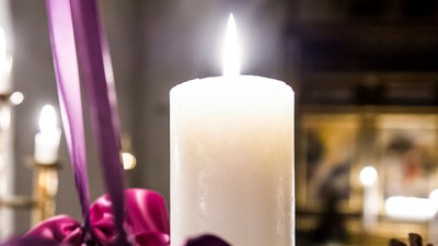 En lysende lysekone med violet bånd og en tannekrans.