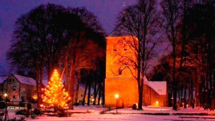Weihnachtsbaum und beleuchteter Turm im Schnee