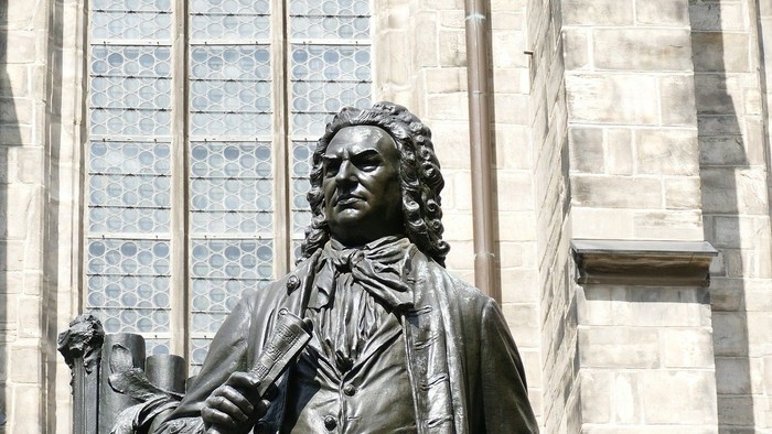 Bronze statue af en mand med krumsabel og papirer.