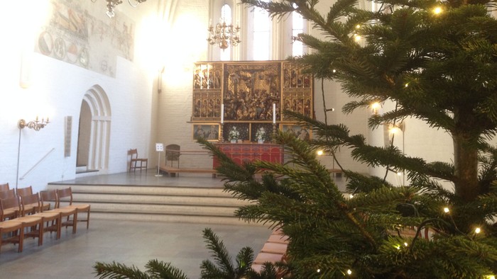 Indre del af kirke med juletree og alter.