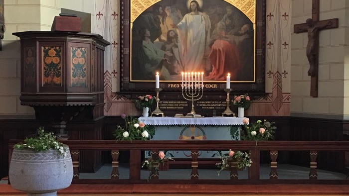 Alter i kirke med altertavle og lysestage