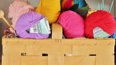 En kiste med forskellige farver af garn og strå.