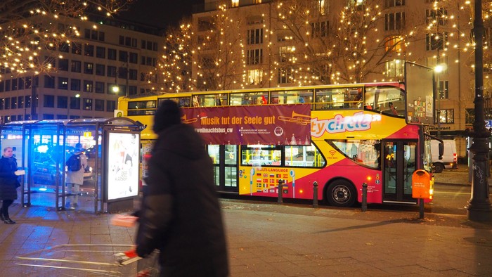 Abendstimmung in der Stadt mit beleuchteten Gebäuden und einem Doppeldeckerbus