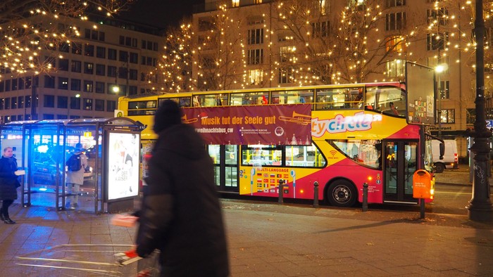 Abendstimmung in der Stadt mit beleuchteten Gebäuden und einem Doppeldeckerbus