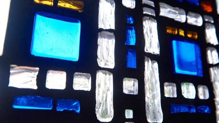 Buntes Glasfenster mit blauen und klaren Quadraten