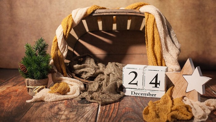 Gemütliche Winterszene mit Wolle, kleinem Baum, Holzklötzen und Stern auf rustikalem Tisch.