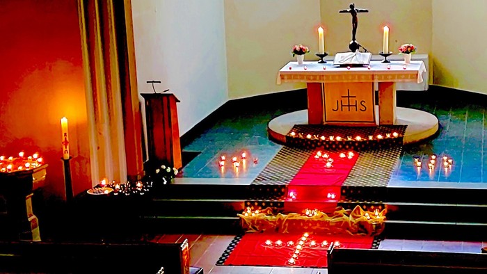 Altarraum der Königin-Luise-Kirche, geschmückt mit vielen Kerzen und Teelichtern am Boden