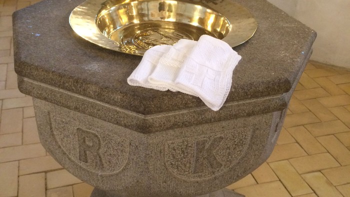 Guldbæger på altertavle i kirke.