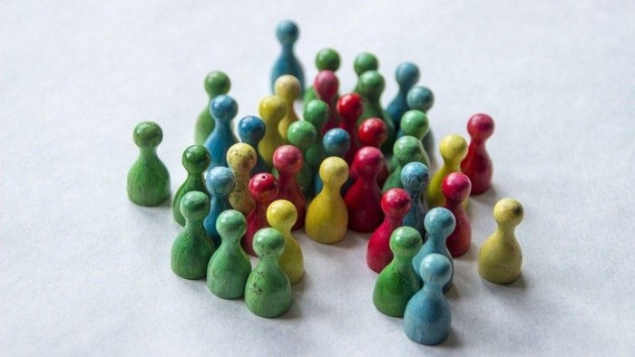 Mensch-ärger-dich-nicht-Männchen stehen eng beieinander als Symbol für die Kontaktgruppe