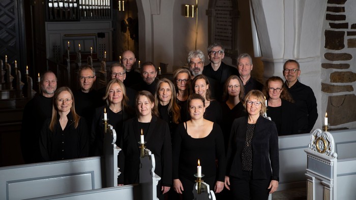 En gruppe af mænd og kvinder poserer sammen i en kirke.