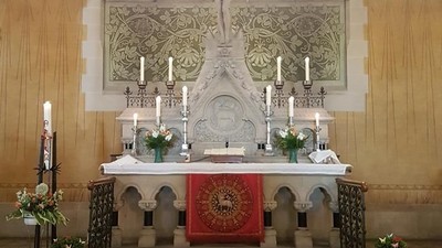 Altar in Kirche mit Kerzen und Blumen
