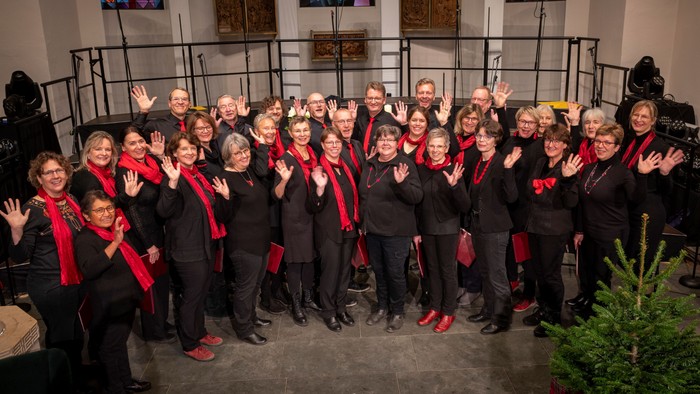 Ein großer Chor in Kirchenraum posiert für Gruppenfoto