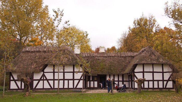 Hvid bondegård med bindingsværk og stråtag.