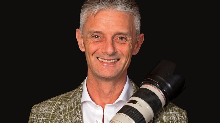 Mand med hvid hår og kamera.