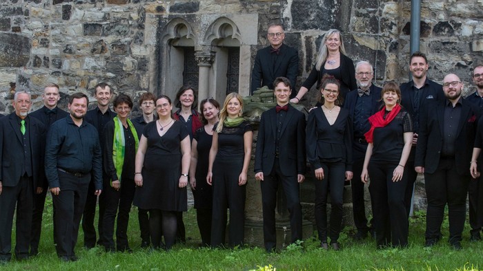 Ein Chor steht vor einem alten Gemäuer.