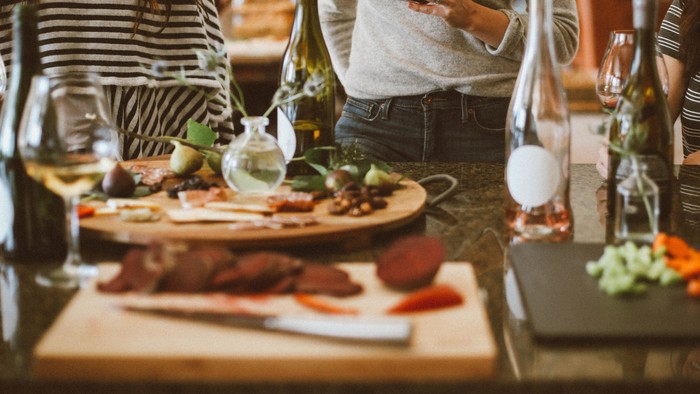 Drei Frauen genießen ein Essen mit Wein und Snacks in einem Restaurant.
