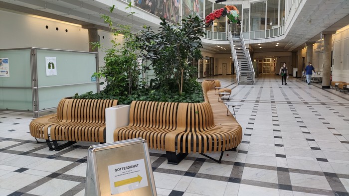 Modernes Einkaufszentrum mit Sitzbänken und Grünpflanzen