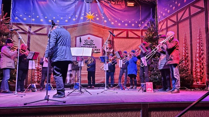 Eine Band spielt auf einer Bühne, ein Mann singt ins Mikrofon