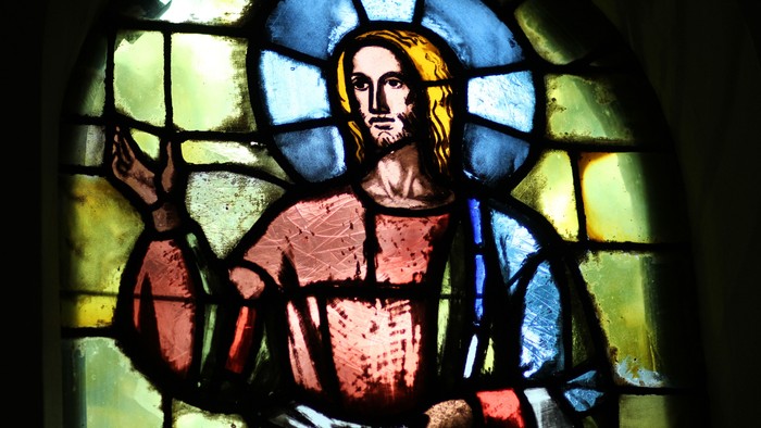 Glassmaleri af Jesus med blå og gule farver