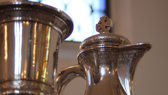 Silverkannen med dekker og håndtag.