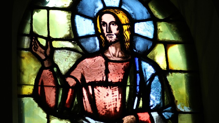 Glassmaleri af Jesus med blå og gule farver