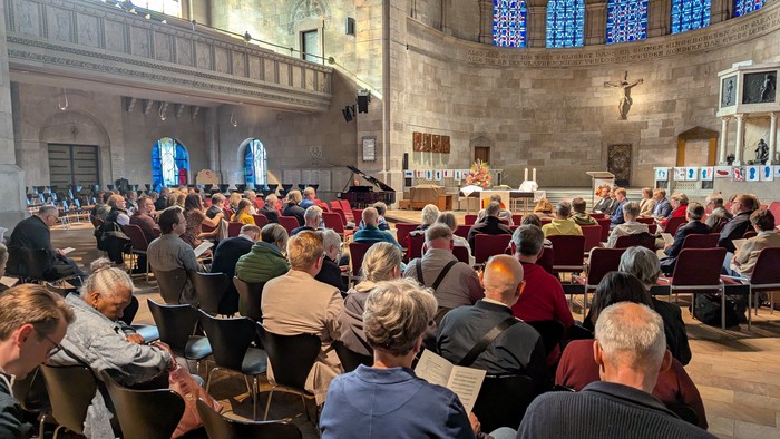 Eine große Gruppe von Menschen versammelt sich in einer historischen Kirche.