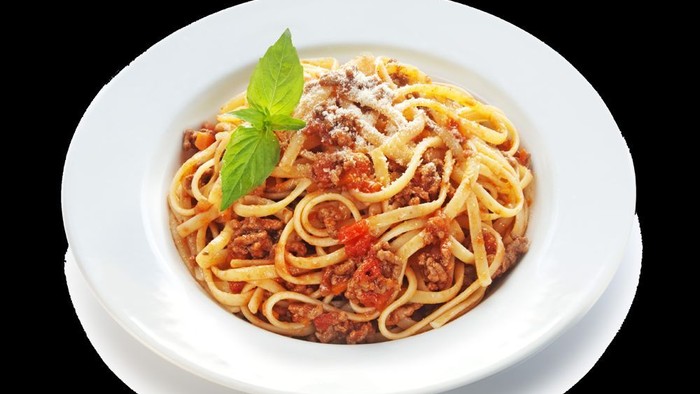 En ret med spaghetti i tomat-saus og parmesan, garnished med basilika.