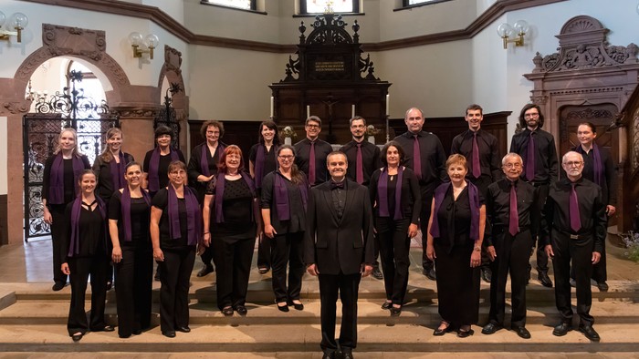 Ein Chor steht in einer Kirche und posiert für ein Gruppenfoto.