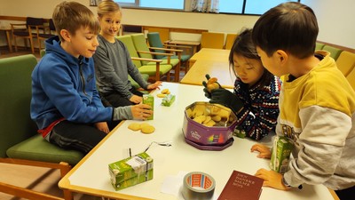 Børn spiser og ser på billeder i bog