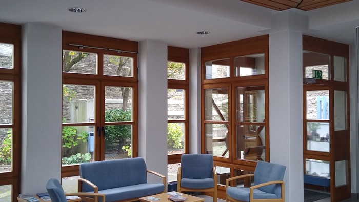 Modernes Wartezimmer mit blauen Stühlen und großen Fenstern