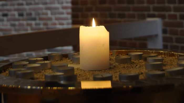 En lysende lyse med guldfarvet dekoration på en bord.