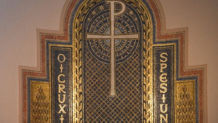 Der Altar einer Kirche mit Kreuz und Blumen.