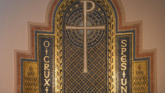Der Altar einer Kirche mit Kreuz und Blumen.