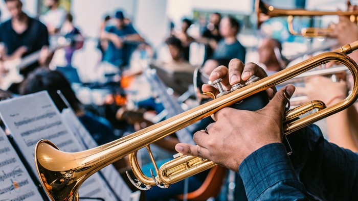 Eine Gruppe von Musikern, die in einem Orchester Blechblasinstrumente spielen.
