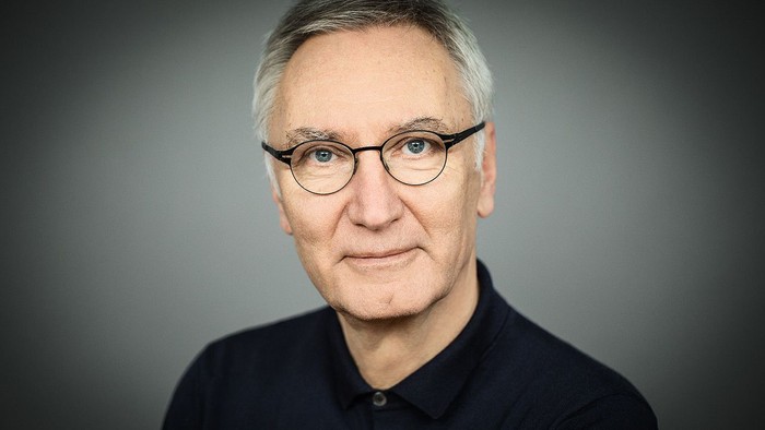 Mann mittleren Alters mit Brille, der ein dunkles Hemd trägt.