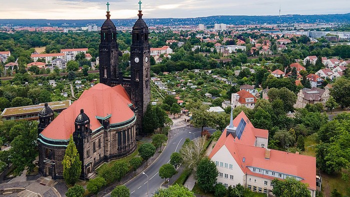 Die Stadtansicht zeigt eine große Kirche mit zwei Türmen und umgebende Häuser.