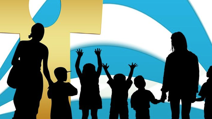 Silhouetten von Erwachsenen und Kindern, die vor einem großen Kreuz und einem blauen Bogen Händchen halten.