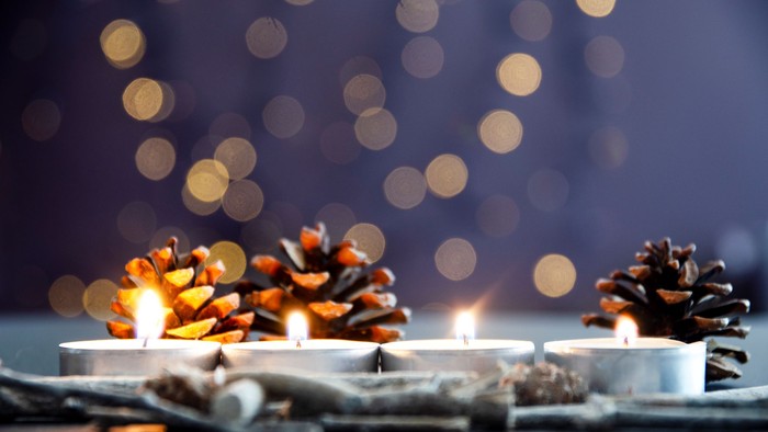 4 brennende Teelichter mit Tannenzapfen