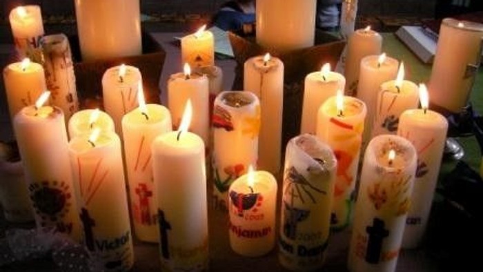 Viele brennende Kerzen in verschiedenen Größen und mit unterschiedlichen Mustern.