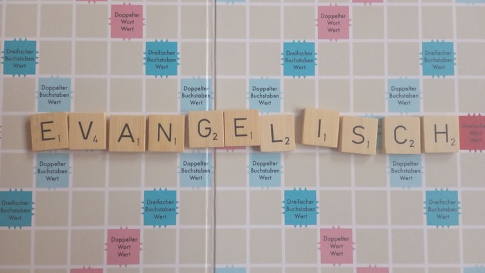 Ein Scrabble-Brett mit dem Wort "E V A N G E L I S C H"
