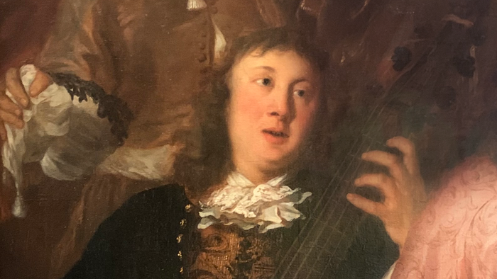 Ein Mann spielt eine Geige, während eine Frau danebensteht