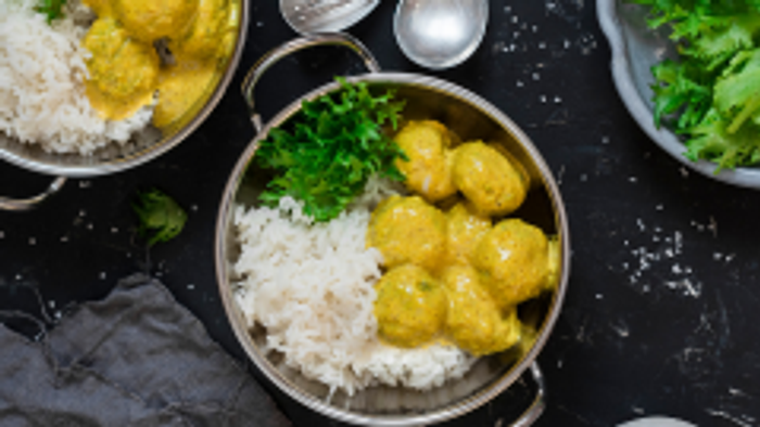 Bowler med ris og grønne bønner på sort bord.