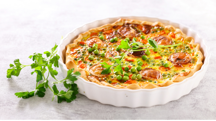 En flødepi, der ser smagfuld ud og er dekket med frisk grønne urter.