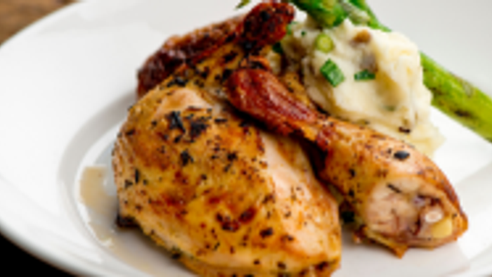 En hvid tælle med stykke kød og grønne stængler.