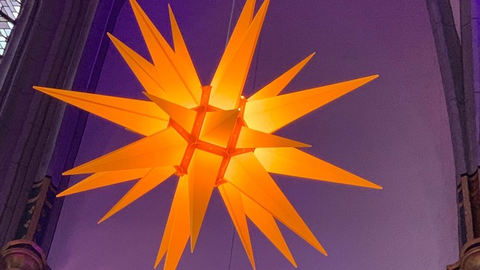 Leuchtende orangefarbene Sterndekoration in Kirche