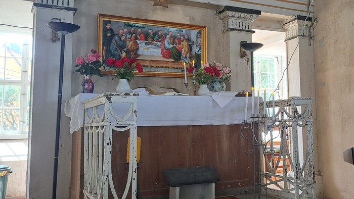 Ein Mann spielt Keyboard in einem Raum mit Altar und Bildern